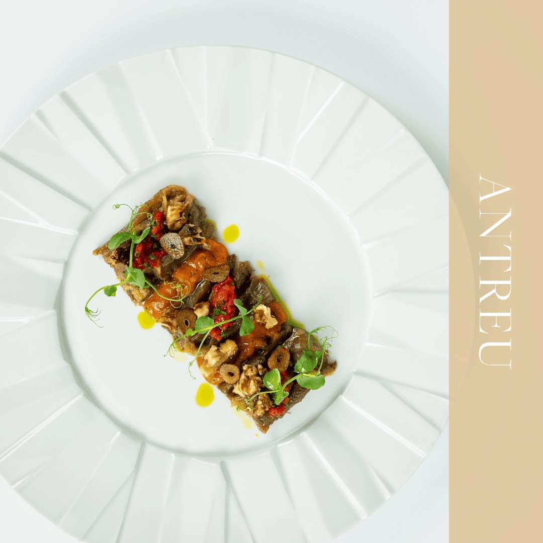 Vânătă afumată cu cremă de roșii, tartar de ardei copt, crumble de nucă, chips de usturoi, ulei de leuștean și ulei picant pe farfurie